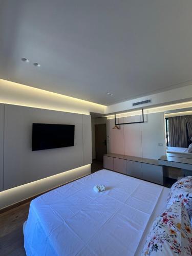 a bedroom with a large bed and a flat screen tv at Manolo & Jolie Luxury Villa in Himare