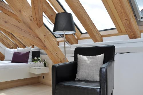 a black chair in a room with wooden ceilings at DIE KRONE - Hotel Garni in Kirchzarten