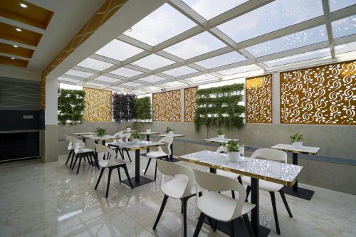 a restaurant with tables and chairs in a room at Open Hotel by Olive - Ejipura in Bengaluru