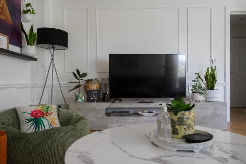 a living room with a tv and a coffee table at City Centre House - 5 Bedrooms - Sleeps 9 in Edinburgh