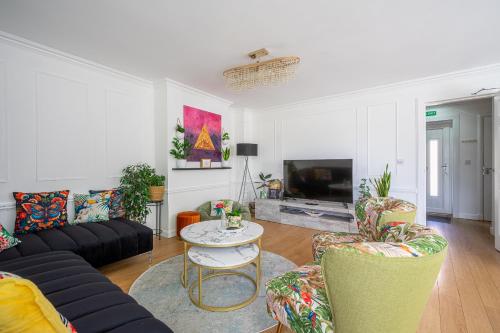 a living room with a couch and a table and chairs at City Centre House - 5 Bedrooms - Sleeps 9 in Edinburgh