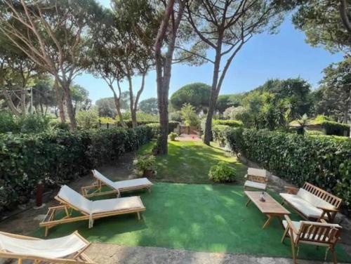a backyard with chairs and a green lawn at Antico Casale dell'800 in Albinia