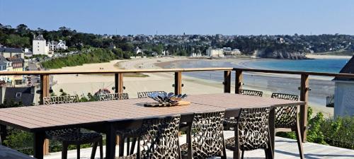 - une table sur un balcon avec vue sur la plage dans l'établissement Maison spacieuse Morgat Vue mer imprenable 5 chambres, terrasse XXL, à Crozon