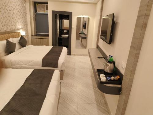 a hotel room with two beds and a television at Veda INN by Chrysdorf in Faizābād