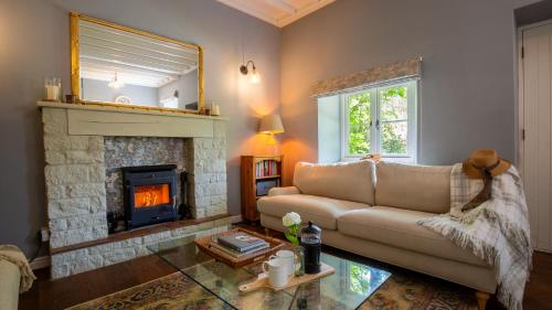 a living room with a couch and a fireplace at Honeywick Cottage in Stow on the Wold