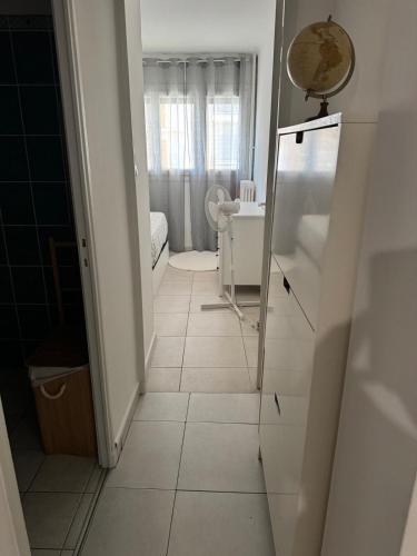 - un couloir doté de carrelage blanc et d'un miroir dans l'établissement Appartement de 3 chambres pour 6 personnes, à Toulon