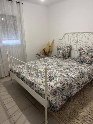 - une chambre avec un lit blanc et un couvre-lit floral dans l'établissement Appartement de 3 chambres pour 6 personnes, à Toulon