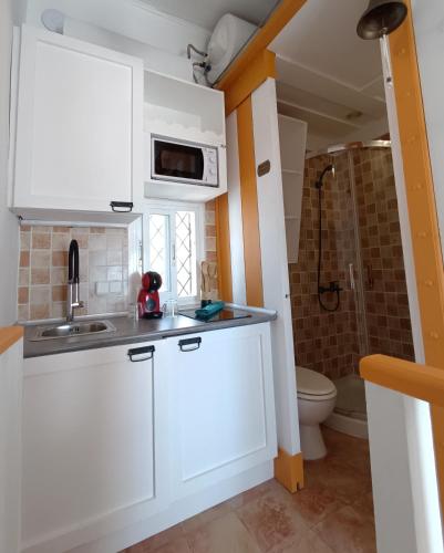 a small kitchen with a sink and a microwave at Cencibel - Harbor's Light in Villajoyosa