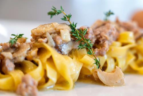 a plate of food with pasta with meat and herbs at AHG Riva Del Sole Hotel - Adults Only in Moniga