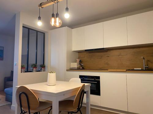 une cuisine avec une table blanche et une table et des chaises dans l'établissement L'Accalmie, à Annecy