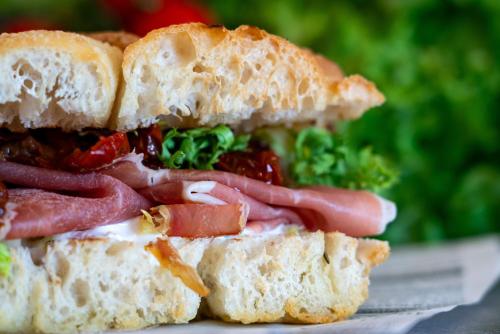 a sandwich cut in half with meat and vegetables at AHG Riva Del Sole Hotel - Adults Only in Moniga
