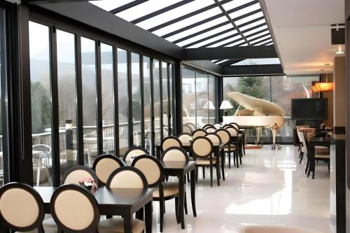 a row of tables and chairs in a room with a piano at Suanbo Park Hotel in Suanbo