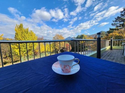 a coffee cup sitting on a table on a balcony at Suanbo Park Hotel in Suanbo