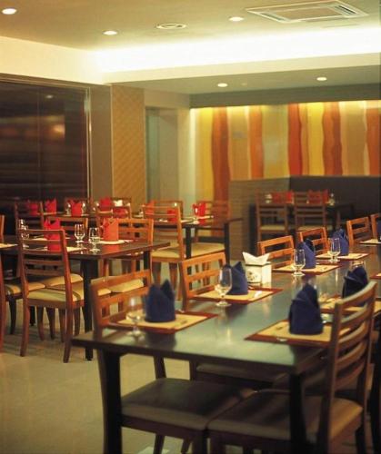 a restaurant with tables and chairs with hats on them at Suanbo Park Hotel in Suanbo