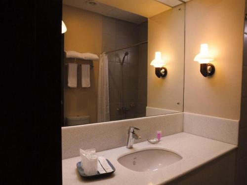 a bathroom with a sink and a large mirror at N Hotel in Cagayan de Oro