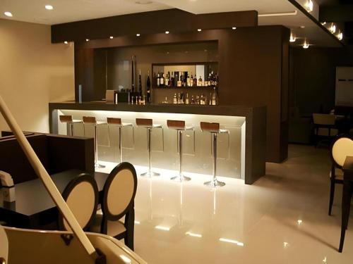 a bar with a row of stools in a room at Suanbo Park Hotel in Suanbo