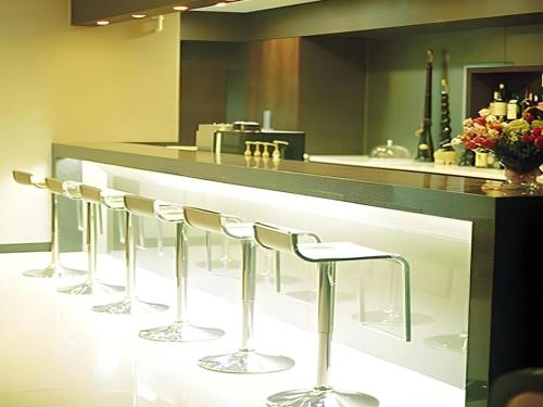 a row of bar stools in front of a counter at Suanbo Park Hotel in Suanbo