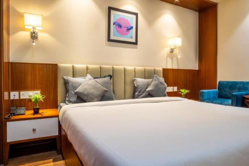 a hotel room with a bed and a blue chair at Housr Sector 42 Gurgaon Golf Course Road Near 42-43 Metro Station in Gurgaon