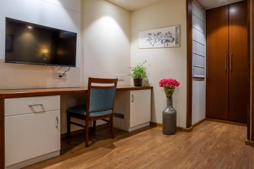 a room with a desk with a tv and a chair at Housr Sector 42 Gurgaon Golf Course Road Near 42-43 Metro Station in Gurgaon