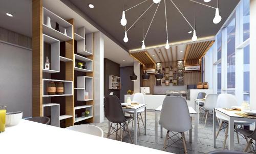 a restaurant with white tables and chairs and a kitchen at Smart Budget Hotel in Semarang