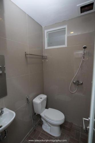 a bathroom with a toilet and a sink at Smart Budget Hotel in Semarang
