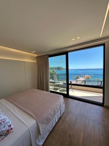 a bedroom with a bed and a view of the ocean at Manolo & Jolie Luxury Villa in Himare