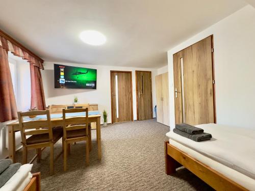 a bedroom with a bed and a dining room with a table at Ubytování Smrk in Nové Město pod Smrkem