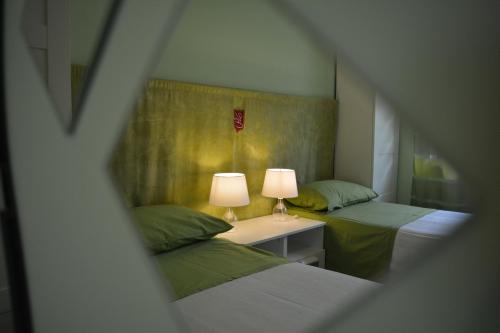 a room with two beds and a table with two lamps at Villa Elena in Montesilvano