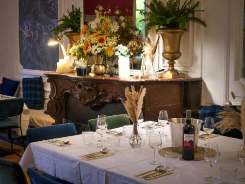 a table with wine glasses and flowers on it at Hôtel Maison Montgrand - Vieux Port in Marseille