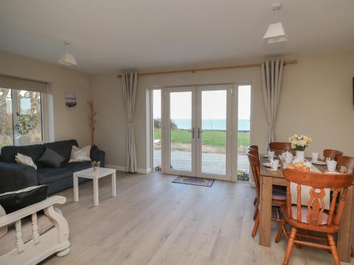 a living room with a couch and a table with chairs at Wood Beach Lodge in New Ross