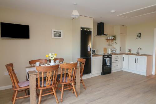 a kitchen and dining room with a table and chairs at Wood Beach Lodge in New Ross