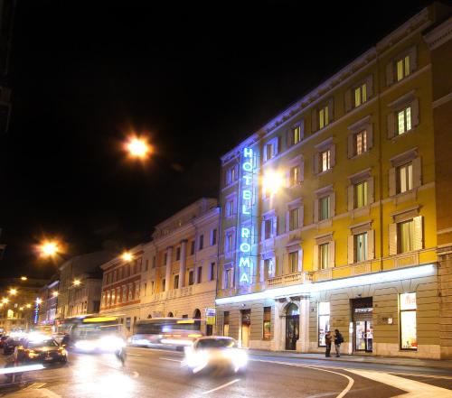 a city street filled with lots of traffic at night at Hotel Roma in Trieste