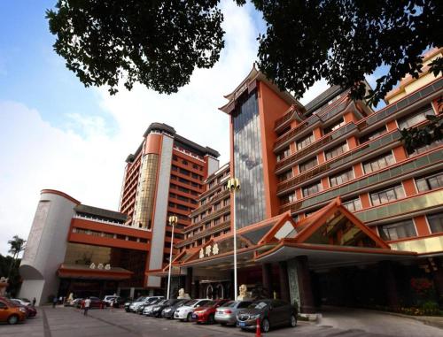a large building with cars parked in a parking lot at Quanzhou Hotel in Quanzhou