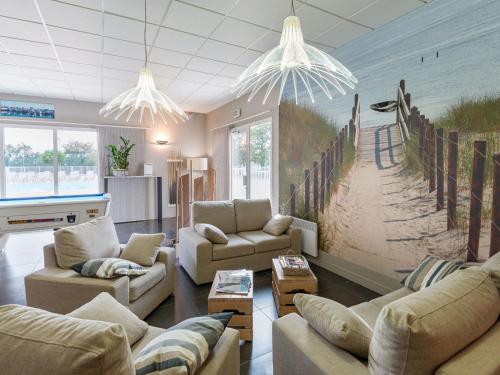 - un salon avec des canapés et une peinture sur la plage dans l'établissement Cozy Holiday Home Near Veillon, à Saint-Hilaire-de-Talmont