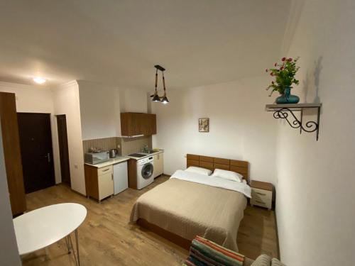a small bedroom with a bed and a kitchen at Квартира у моря Колхида in Makhinjauri