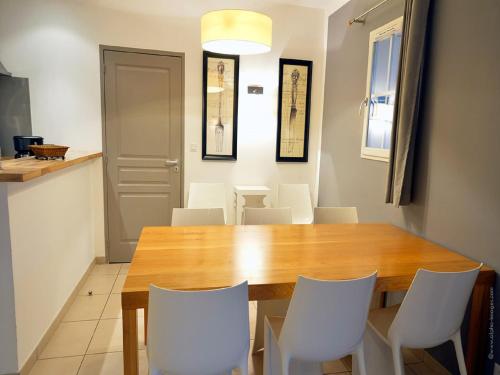 une salle à manger avec une table en bois et des chaises blanches dans l'établissement Villa in Provence with Private Pool, à Saint-Saturnin-lès-Apt