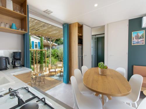 une cuisine et une salle à manger avec une table et des chaises en bois dans l'établissement Mobile Home Near Beach, au Grau-dʼAgde
