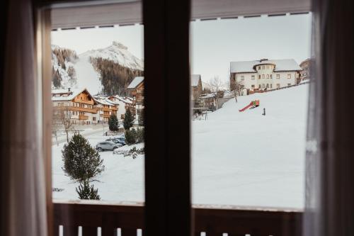 a window with a view of a snow covered mountain at Stella Due in Arabba