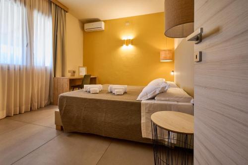 a hotel room with a bed and a table at Delfino Tuscany Resort in Marina di Cecina