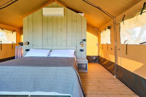 a bedroom with a bed in a tent at Delfino Tuscany Resort in Marina di Cecina