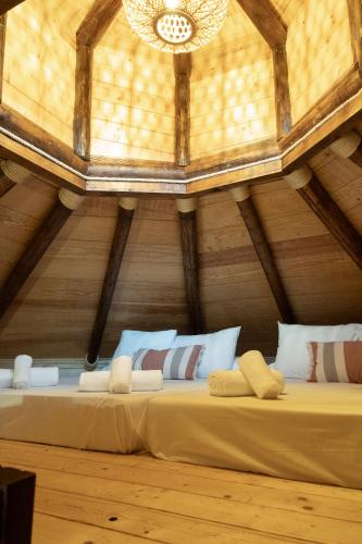 a bed in a room with a wooden ceiling at Cabaña Etiopía in Tarifa