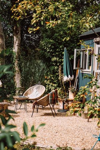 a patio with a table and a bench and an umbrella at The Hyde in Cuckfield