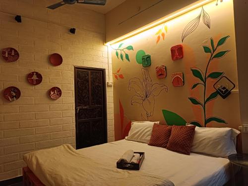 a bedroom with a bed and a wall with flowers at Sukoon River Homestay in Varanasi