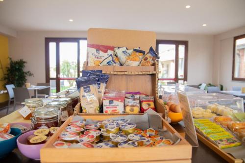 a table topped with boxes of food on a table at Delfino Tuscany Resort in Marina di Cecina