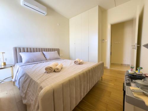 a bedroom with a large bed with towels on it at Avalon Gardens Pink&Blue Villa with swimming pools sauna restaurant gym in Emba
