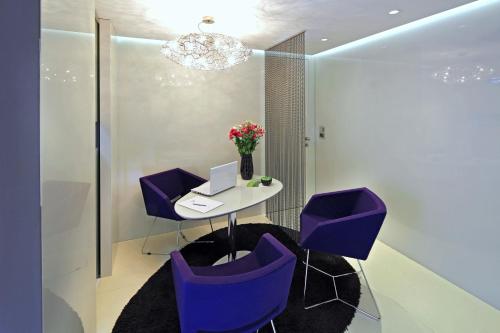 a office with purple chairs and a table with a laptop at Boutique Hotel Adoral in Rabac