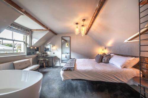 a bedroom with a bed and a tub in a room at The Chequers Inn, Thornham in Thornham