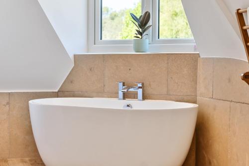 a white sink in a bathroom with a window at The Folly, Thorpe Forest in Brettenham