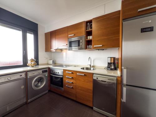 a kitchen with a stainless steel refrigerator and a dishwasher at Apartamentos Verdemar (VUT) in Llanes