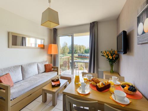 un salon avec une table et un canapé dans l'établissement Apartment in Sables d'Or near Golden Beach, aux Sables-dʼOr-les-Pins